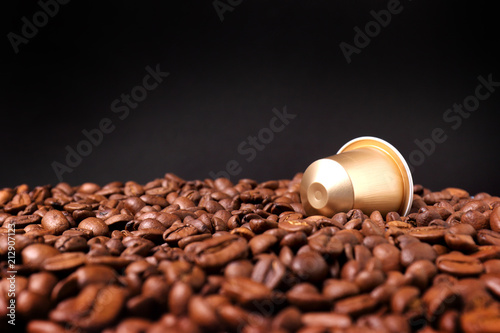 espresso capsules on the background of roasted coffee beans