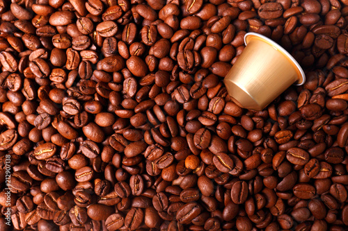 espresso capsules on the background of roasted coffee beans