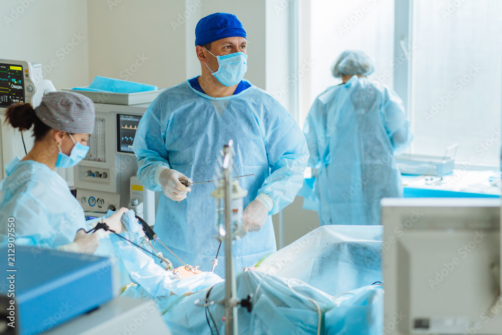 Team surgeon at work on laparoscopy operating in hospital. Top view Team surgeon at work on laparoscopy operating in hospital. Top view