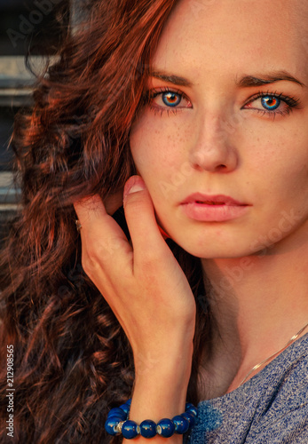 Close up portrait of a beautiful red haired girl. Amazing model looking at camera. Warm art colorized