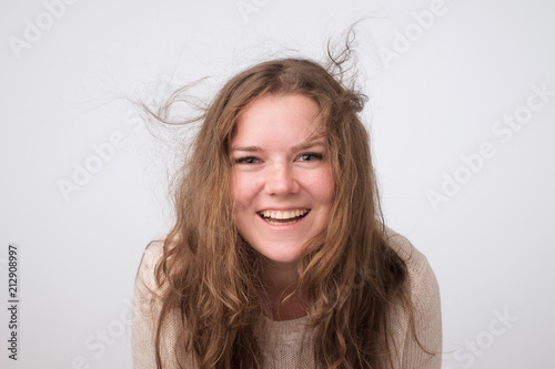 Laughing caucasian plump girl with natural make up looking at camera. Close up photo studio shoot. She is enjoying life. Positive mind and facial emotion
