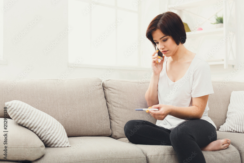 Pensive girl with pregnancy test at home Pensive girl with pregnancy test at home