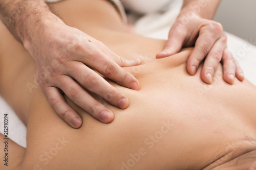 Closeup of hands massaging female shoulders and back © Prostock-studio