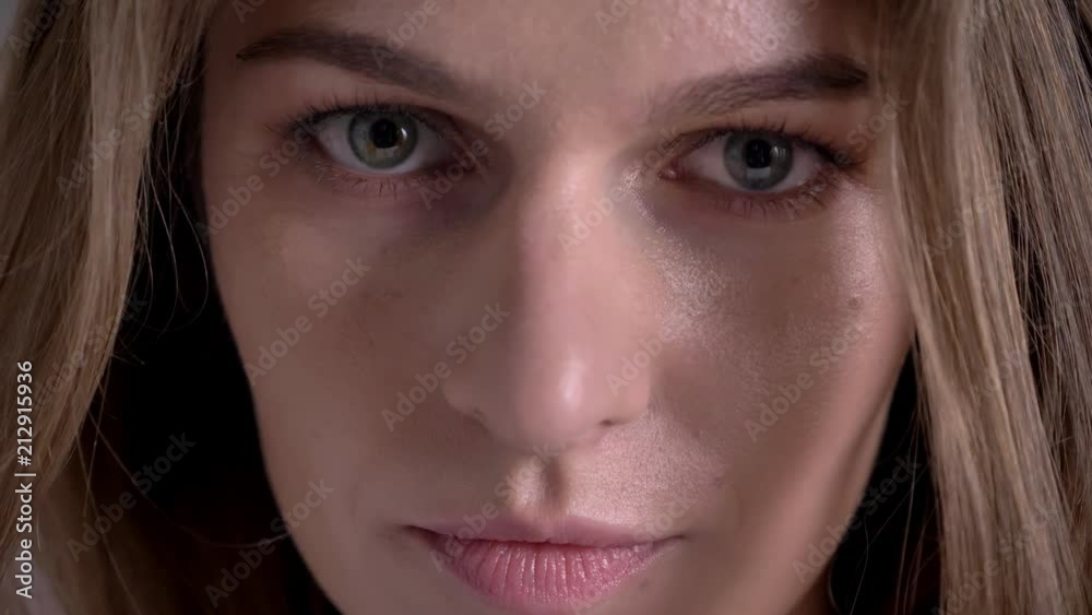 Face of young serious woman is watching at camera Face of young serious woman is watching at camera