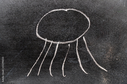 White color chalk hand drawing in jellyfish shape on blackboard background photo