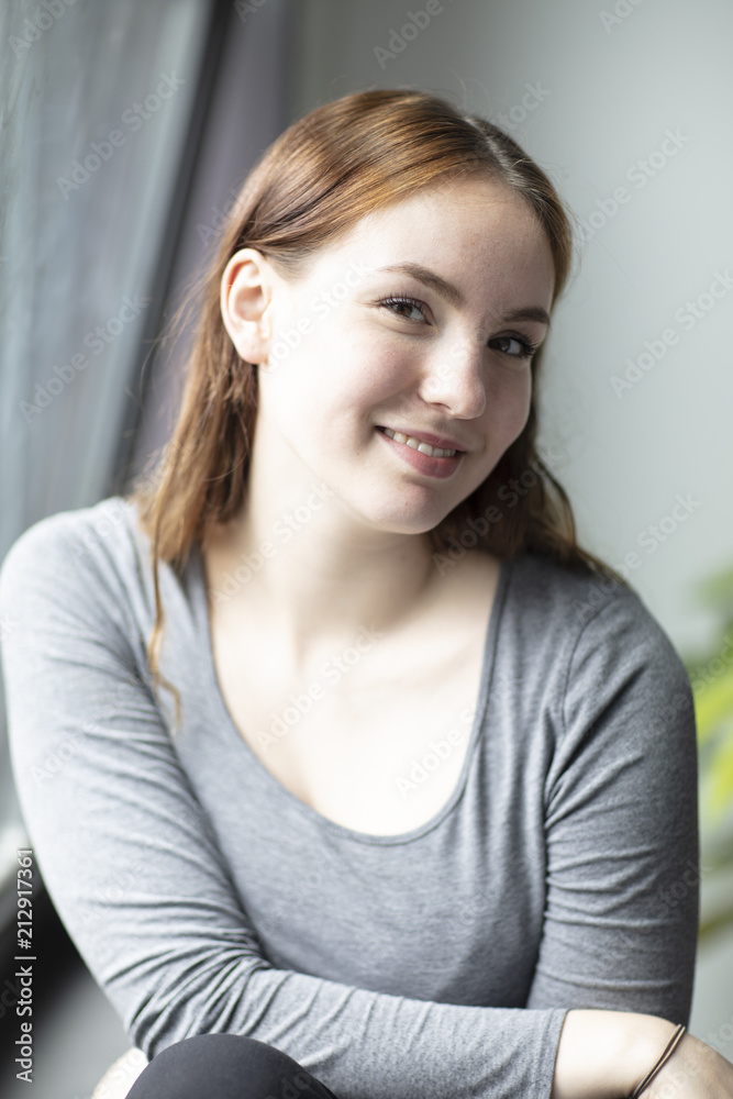 Beauty Portrait of a Young Woman Smiling Seated by Window Beauty Portrait of a Young Woman Smiling Seated by Window