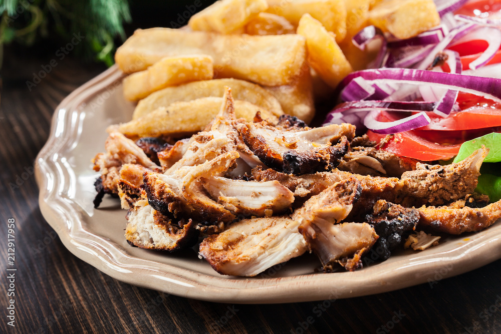 Greek gyros dish with french fries and vegetables Greek gyros dish with french fries and vegetables