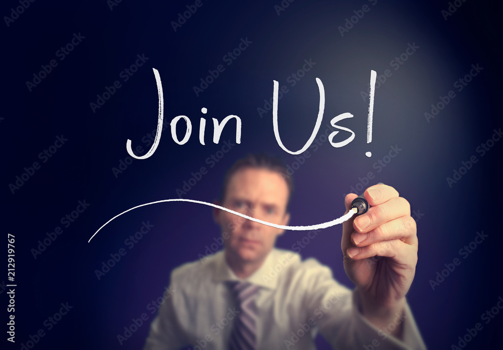 A businessman writing a join us concept with a white pen on a clear screen. A businessman writing a join us concept with a white pen on a clear screen.