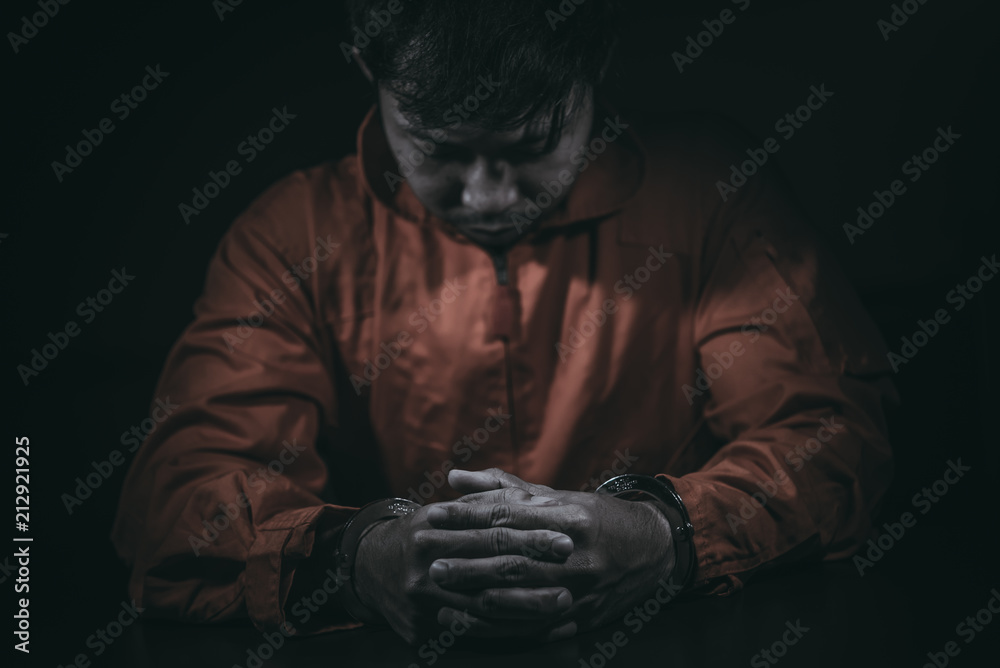The suspect wear prisoner cloths was arrested at the investigation, interview to find out the truth, the thief was caught by the police come to the dark room,Thailand people,Knife in hand The suspect wear prisoner cloths was arrested at the investigation, interview to find out the truth, the thief was caught by the police come to the dark room,Thailand people,Knife in hand