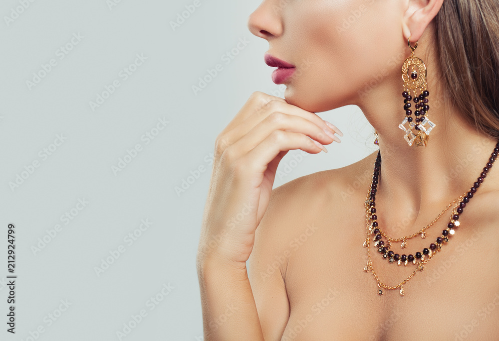 Gold jewelry on woman neck closeup. Necklace and Earrings on female body on background with copy space