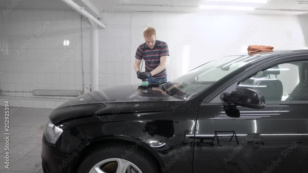 Worker grindering car in garage Worker grindering car in garage