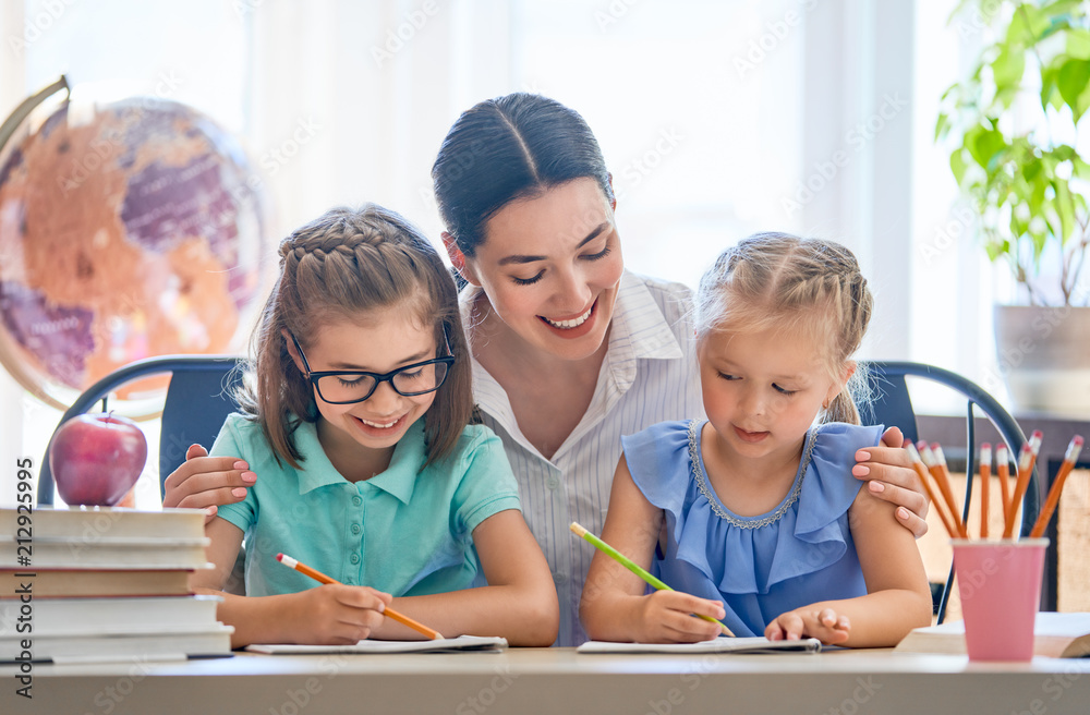 Fototapeta premium Mother and daughters are learning to write