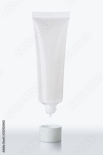 Empty Plasticc Tube of cream opern cap and dropping lotion on white background for your design