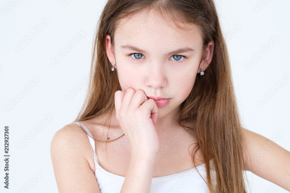 serious child thinking over something. hand under the chin. little girl portrait on white background. mood feelings personality and facial expression concept serious child thinking over something. hand under the chin. little girl portrait on white background. mood feelings personality and facial expression concept