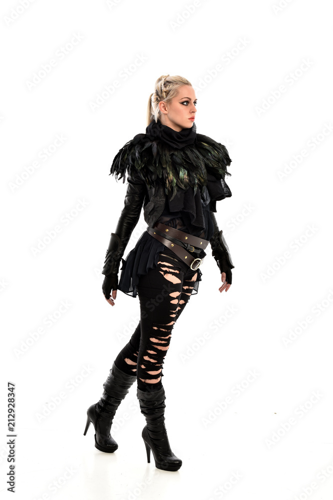 full length portrait of blonde girl wearing torn black feather costume. standing pose, isolated on white background.