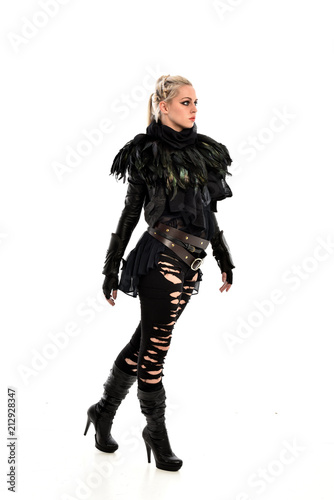full length portrait of blonde girl wearing torn black feather costume. standing pose, isolated on white background.