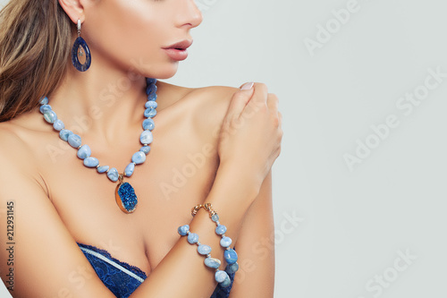 Glamorous woman wearing blue necklace, bracelet and earrings