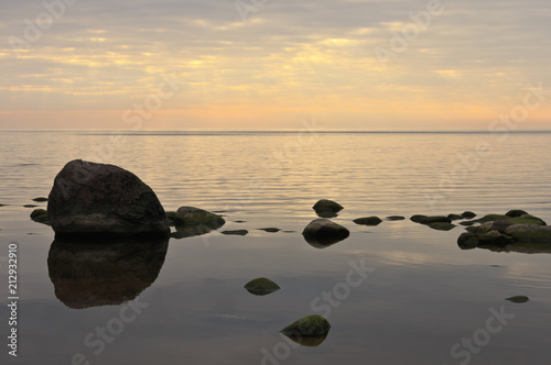 The rocky coast of the Baltic Sea at sunset. © artmans