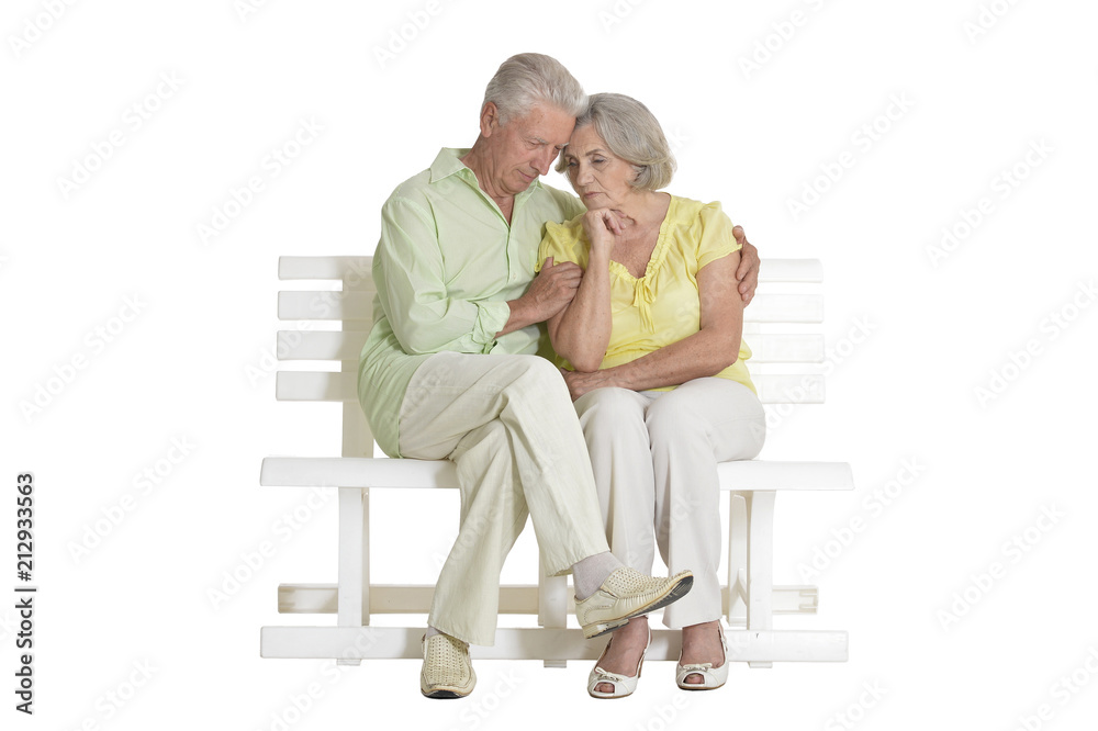 sad senior couple sitting on bench