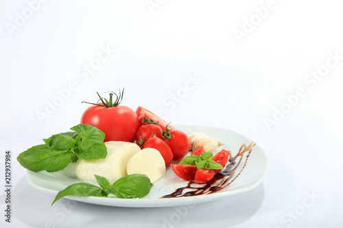 Mazzarella, pomidor, czosnek i bazylia na białym tle.