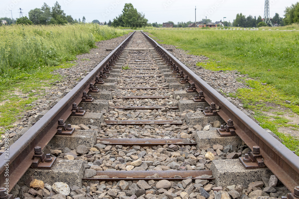 View of Railway tracks approaching to exterior facade of Auschwitz Birkenau concentration camp View of Railway tracks approaching to exterior facade of Auschwitz Birkenau concentration camp
