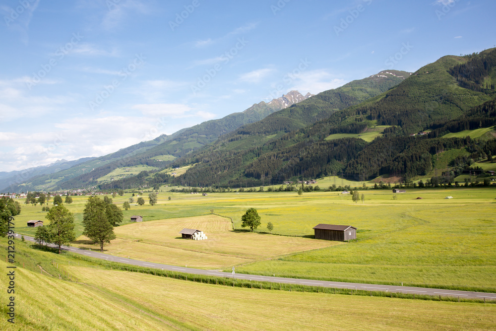 View on the empty Mittersiller Strasse road connecting the villages of Mittersil and Zell am See with valley meadows.