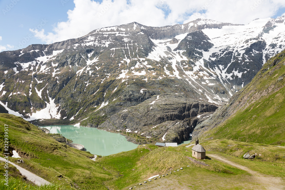 Solitary chapel near the emerald green Margaritze stausee lake on the Grossglockner High Alpine Road.