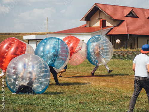 People play bumperball zorbsoccer outdoor. summer time photo