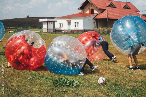 People play bumperball zorbsoccer outdoor. summer time