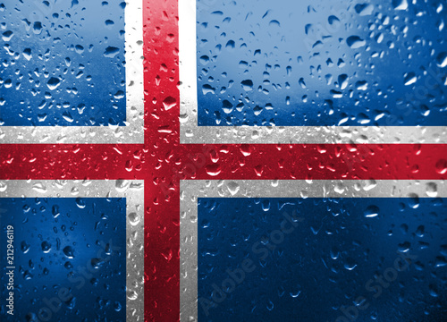 Texture of Iseland flag on the glass with drops of rain. photo