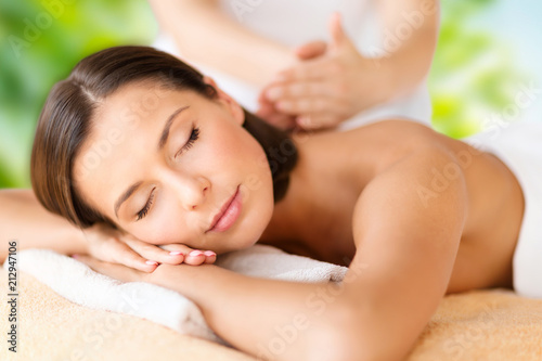 wellness  spa and beauty concept - close up of beautiful woman having massage over green natural background