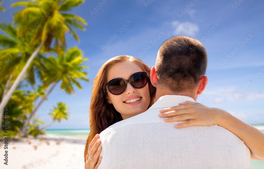 travel, tourism and summer vacation concept - happy couple hugging over tropical beach background in french polynesia travel, tourism and summer vacation concept - happy couple hugging over tropical beach background in french polynesia