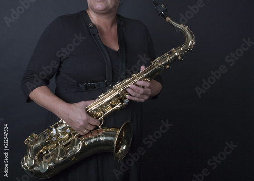 Vrouw houdt saxofoon schuin vast photo