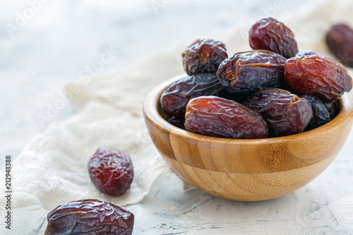 Dried fruits of date palm in a wooden bowl.