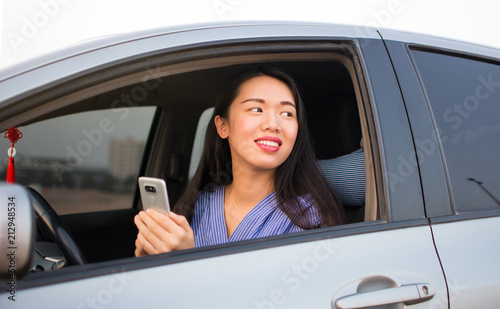 Asian girl using phone in car