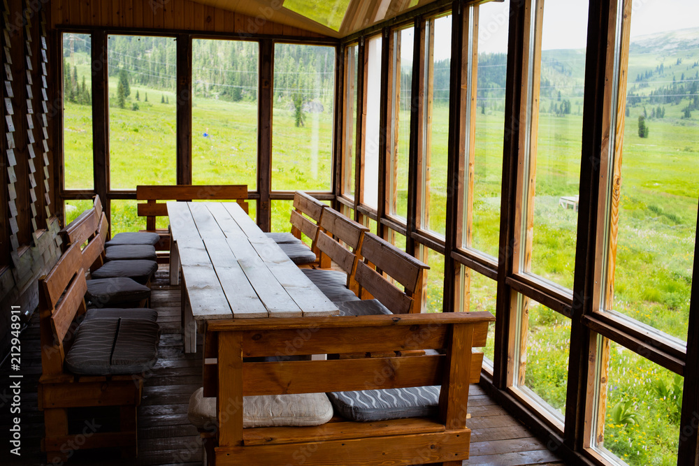 Empty balcony with tables, chairs with mountain and meadows view