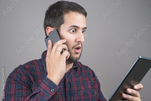 Portrait of surprised man talking on smartphone