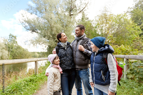 family, tourism and hiking concept - happy mother, father, son and daughter with backpacks in woods © Syda Productions