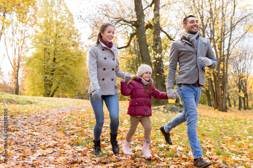 family, season and people concept - happy mother, father and little daughter walking at autumn park family, season and people concept - happy mother, father and little daughter walking at autumn park