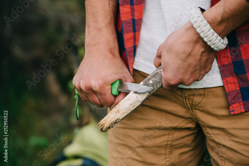 cropped shot of man sharpening log with knife