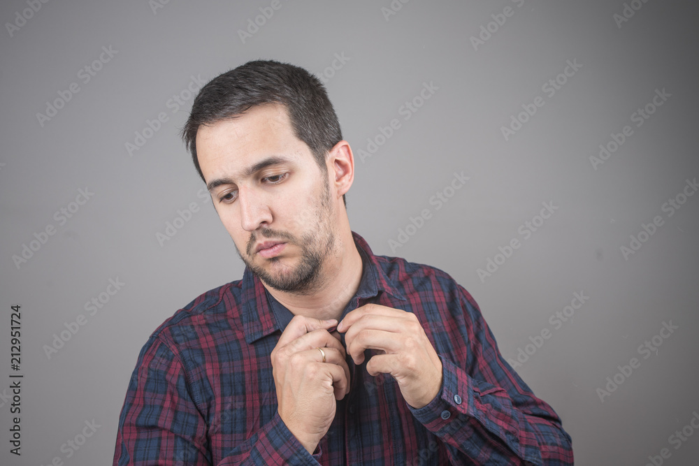 Portrait of man buttoning his checked shirt Portrait of man buttoning his checked shirt