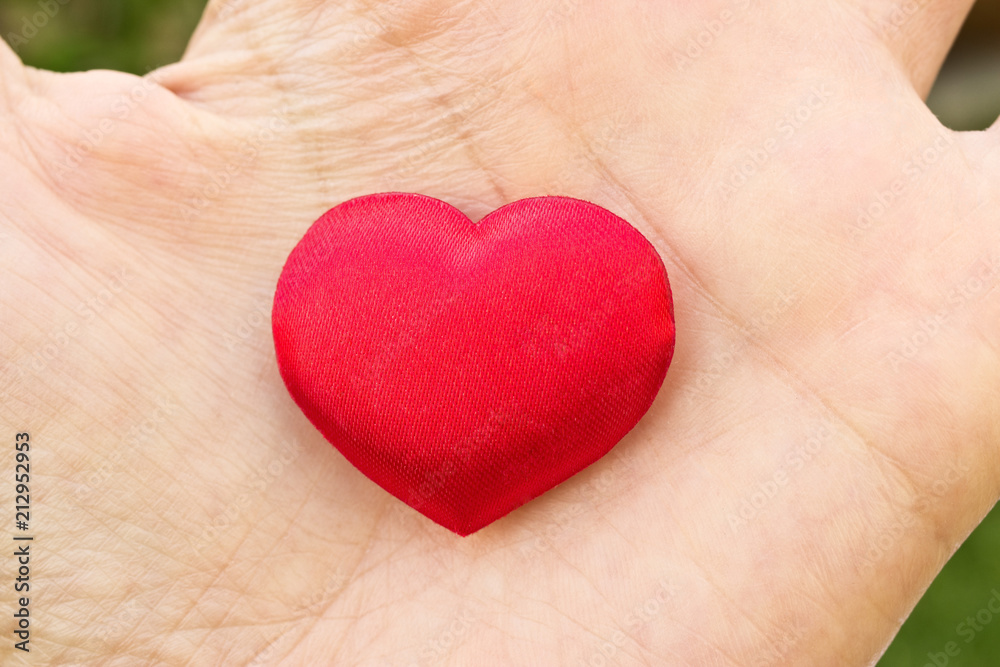 Heart in hand. Romantic concept. Big red heart in woman´s open palm. Symbol of love to everybody. Heart in hand. Romantic concept. Big red heart in woman´s open palm. Symbol of love to everybody.