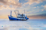 Blue - White Fishing Boat In The Sea And Dramatic Clouds At Sunrise.
