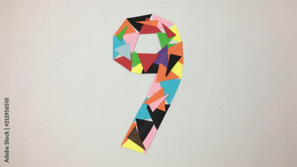 Numero nueve hecho de triangulos de colores se deshace por el viento.