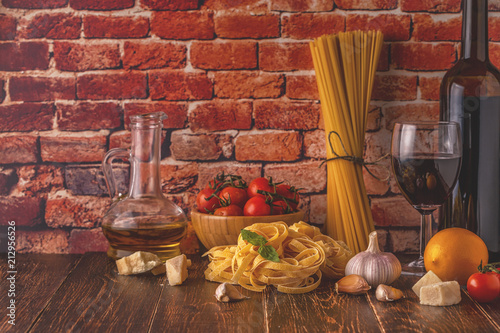 Products for cooking - pasta, tomatoes, garlic, olive oil and red wine.