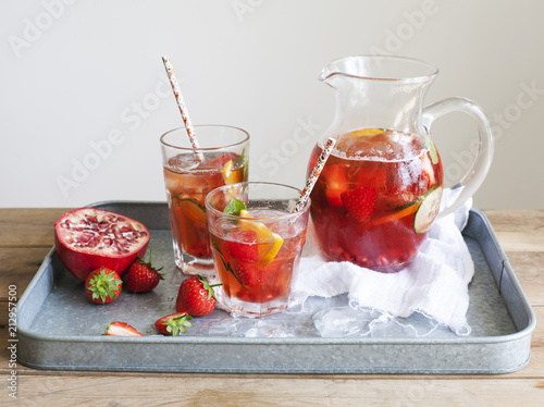 Pomegranate Pimms in jug with fruit on metal tray photo