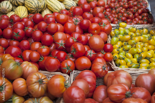Mixed tomatoes in baskets on market stall