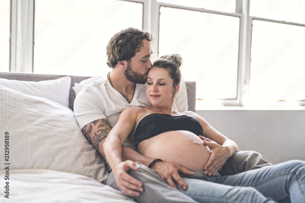 Man with pregnant woman in bed at home having great time Man with pregnant woman in bed at home having great time