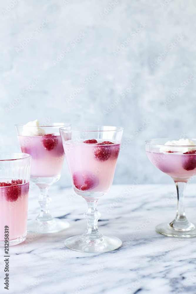 Pink lemonade jelly with raspberries on light marble background Pink lemonade jelly with raspberries on light marble background