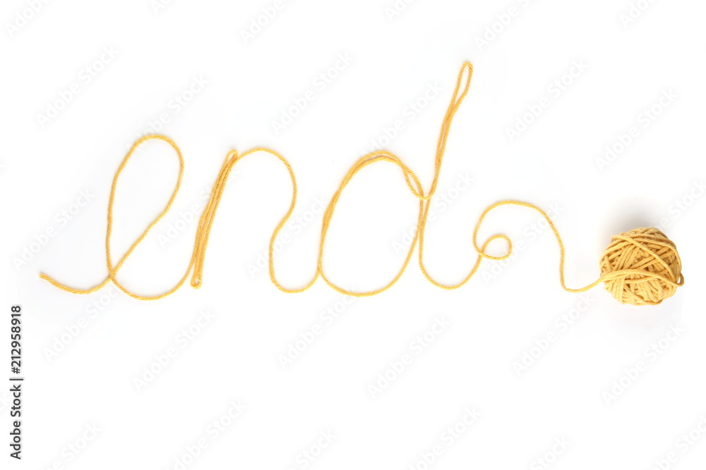 Word end made of yellow thread and thread ball isolated on white background. Cotton thread ball with word end. Word end made of yellow thread and thread ball isolated on white background. Cotton thread ball with word end.